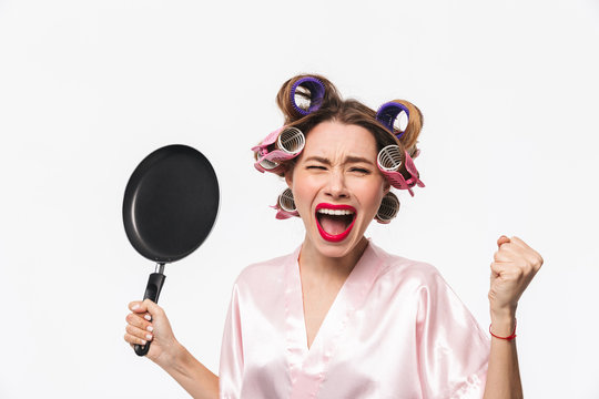 Angry housewife with curlers in hair standing