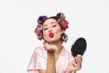 Beautiful housewife with curlers in hair wearing robe