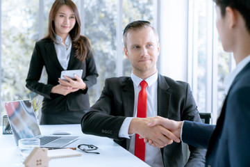 Businessman shake hands agree deal of big lot sales that finish goal of marketing plans of the company