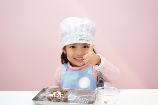 Asian Kid Wearing Chef Uniform Thumps Up  With Confident.  