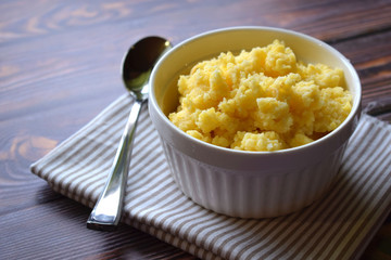 Useful cornmeal porridge on wooden background.