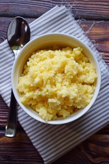 Useful cornmeal porridge on wooden background.