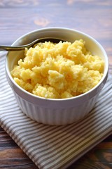 Useful cornmeal porridge on wooden background.