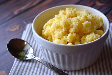 Useful cornmeal porridge on wooden background.