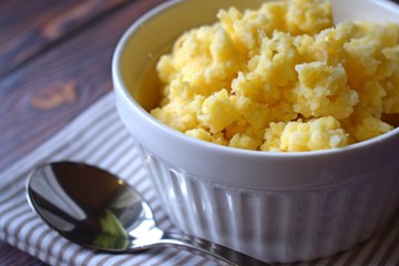 Useful cornmeal porridge on wooden background.