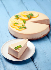 Lemon cheesecake decorated with citron and mint on wooden background. Healthy organic summer dessert pie