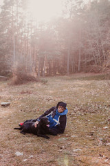 Man with his black labrador dog standing in the forest at sunset. healthy lifestyle. Hiking