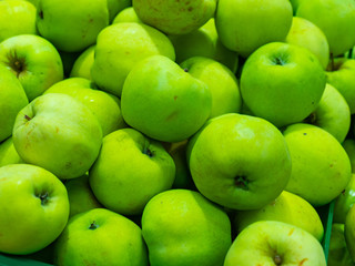 Bunch of green and red apples on boxes in supermarket.