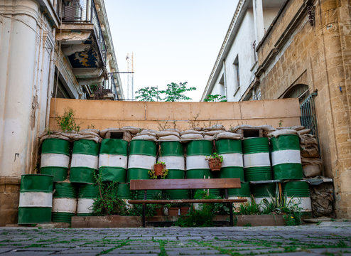 Wall with barrels and crenels marking the green line in the UN buffer zone between Greece and Turkey in Cyprus, Nicosia. 