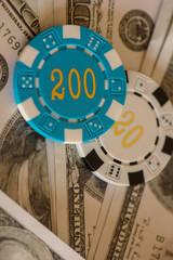 Two casino chips with several dollar bills