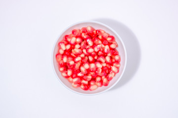 pomegranate seeds in a white bowl