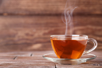 Kopje thee met stoom op bruin houten tafel