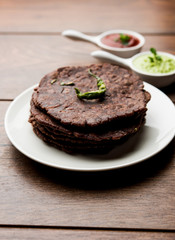 Ragi roti or flat Bread made using finger millet is a healthy and tasty breakfast dish of Karnataka, India. served with green chilli and chutney. selective focus