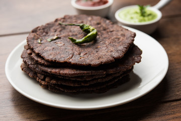 Ragi roti or flat Bread made using finger millet is a healthy and tasty breakfast dish of Karnataka, India. served with green chilli and chutney. selective focus
