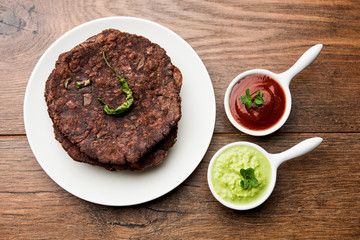 Ragi roti or flat Bread made using finger millet is a healthy and tasty breakfast dish of Karnataka, India. served with green chilli and chutney. selective focus