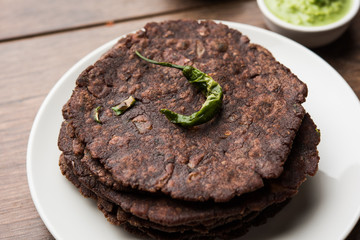 Ragi roti or flat Bread made using finger millet is a healthy and tasty breakfast dish of Karnataka, India. served with green chilli and chutney. selective focus