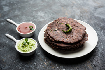 Ragi roti or flat Bread made using finger millet is a healthy and tasty breakfast dish of Karnataka, India. served with green chilli and chutney. selective focus
