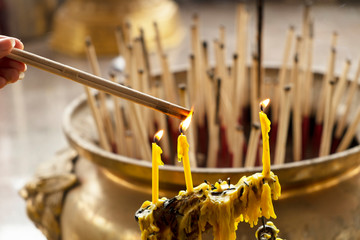Burning aromatic incense sticks in temple for praying Buddha or Hindu gods to show respect