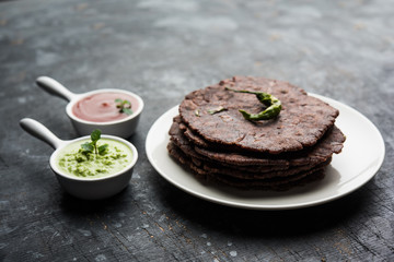 Ragi roti or flat Bread made using finger millet is a healthy and tasty breakfast dish of Karnataka, India. served with green chilli and chutney. selective focus