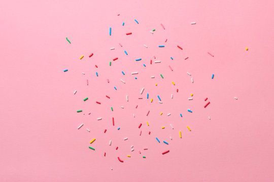 beautiful sugar colorful sprinkles over pink background