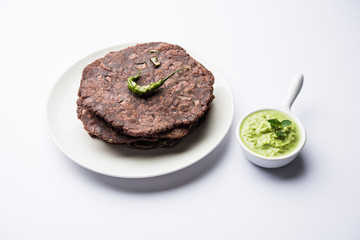 Ragi roti or flat Bread made using finger millet is a healthy and tasty breakfast dish of Karnataka, India. served with green chilli and chutney. selective focus