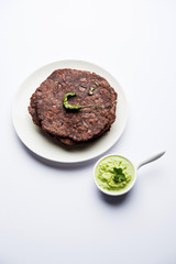 Ragi roti or flat Bread made using finger millet is a healthy and tasty breakfast dish of Karnataka, India. served with green chilli and chutney. selective focus