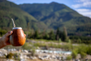 Man holding calabash yerba mate in nature. Travel and adventure concept. Latin American drink yerba...