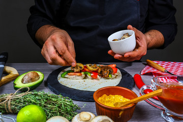 Chef making tacos. Tasty mexican cuisine preparing mexican burito