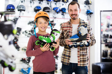 Positive man and son boasting roller-skates