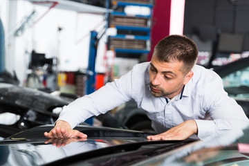 Male checking car painting quality