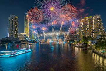 Obraz premium Fantastic Multicolor Firework exploding over the Bangkok Cityscape river side for Celebration, Business architecture and celebration and happy new year and merry christmas concept