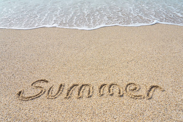Summer inscription on a tropical sandy beach with blue sea, waves and foam on a background.