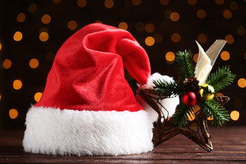 Obraz na płótnie Canvas Santa claus hat with decorative star on bokeh lights background