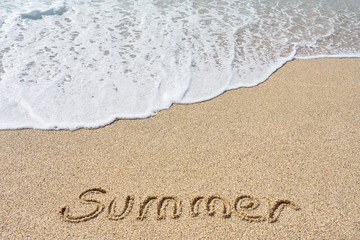 Summer inscription on a tropical sandy beach with blue sea, waves and foam on a background.