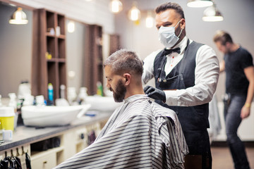 Hipster man client visiting haidresser and hairstylist in barber shop.