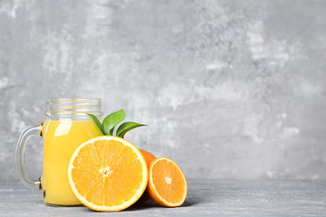 Orange juice in glass jar on grey wooden table