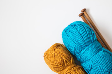 Knitting background. Turquoise and orange wool with wooden knitting needles