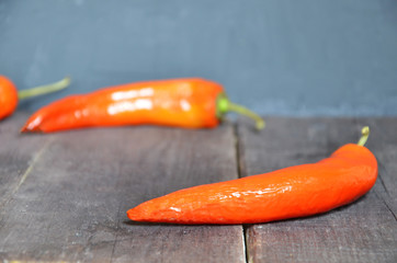 red hot chili pepper corns and pods on dark vintage background, top view.