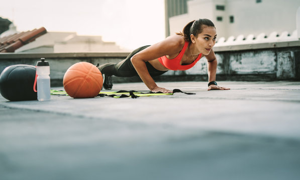 Female athlete doing fitness workout on rooftop - Powered by Adobe