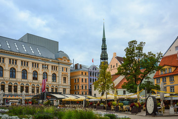 Obraz premium Riga, Latvia - September, 30, 2018: Square in the center of old Riga with old buildings, cafe and view of the medieval cathedral St. Peter's Church.