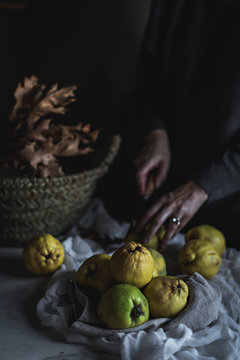 Crop woman peeling exotic fruit over basket