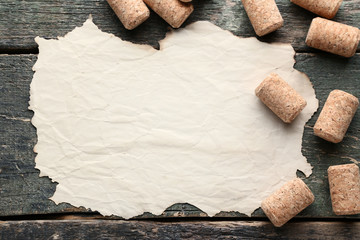 Wine corks with blank of paper on grey wooden table
