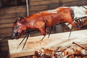 Whole grilled pig with meat steak on cutting board. Hot Meat