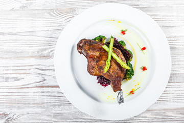 Grilled pork chop steak on the bone with asparagus and broccoli on light wooden background close up. Hot Meat Dishes. Top view