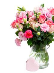 Rose and eustoma fresh flowers bouquet in two shades of pink in glass vase close up isolated on white background