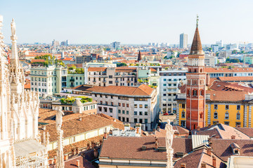 Fototapeta premium White statue on top of Duomo cathedral and view to city of Milan