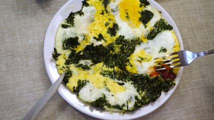 First perspective view. The process of eating scrambled eggs with spinach.
