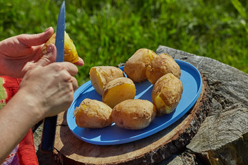 Woman peeling boiled potatoe.