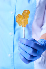 Lollipop in a clear golden luminous sugaring paste for depilation