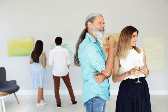 Senior Man And Woman At Exhibition In Art Gallery